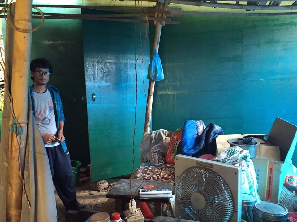 Der Student Saroj Shakya steht in einem winzigen Holzverschlag, in dem er mit der Familie seit Monaten lebt.