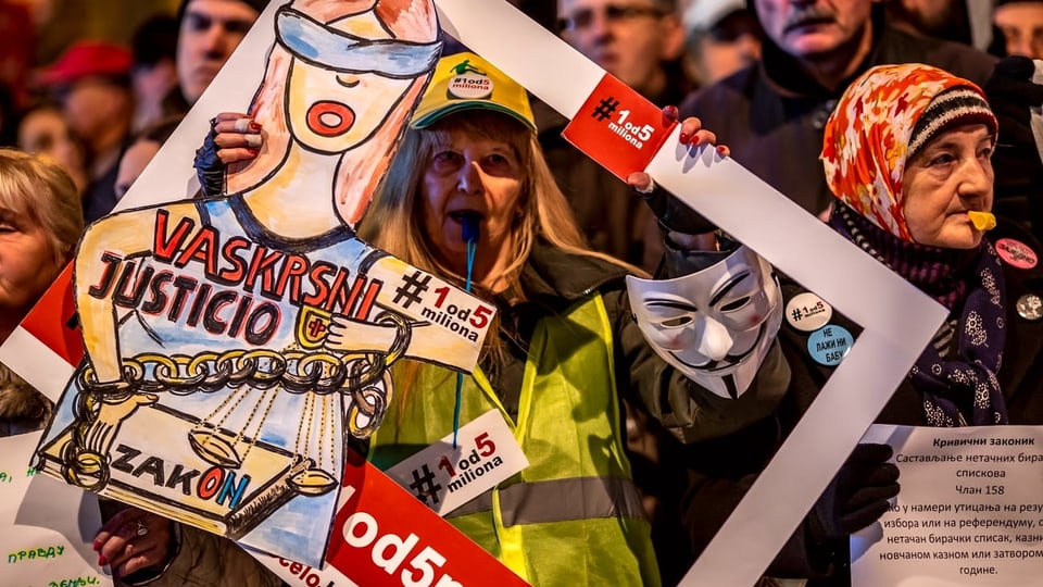 Eine Demonstrantin mit einem Plakat gegen Vucic