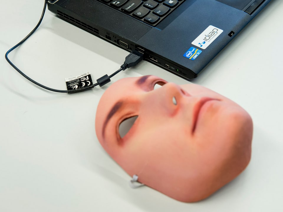 Eine Gesichtsmaske neben einem Computer.