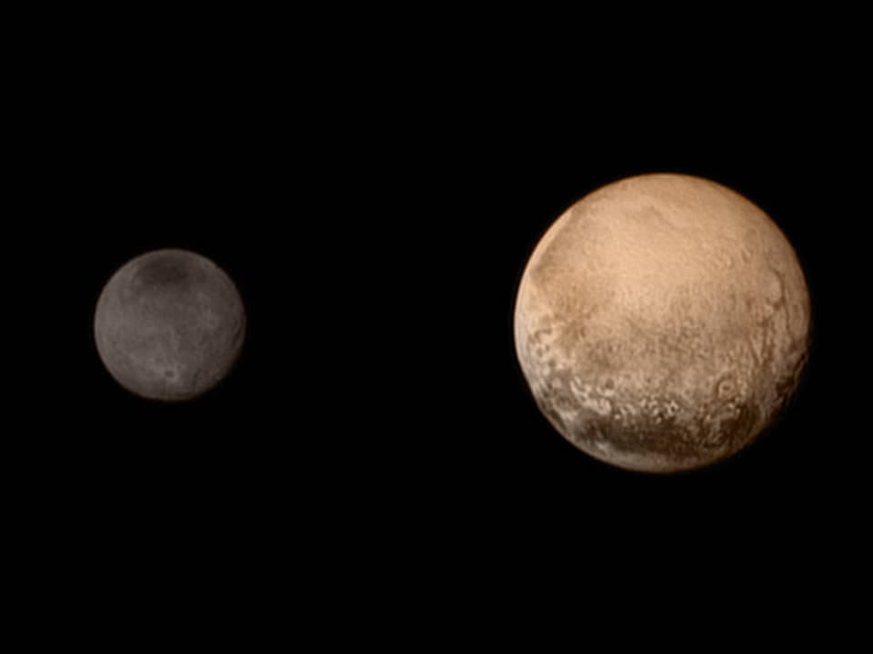 Im Vordergrund der bronzefarbene Zwergplanet Pluto, im Hintergrund, grau, Charon.