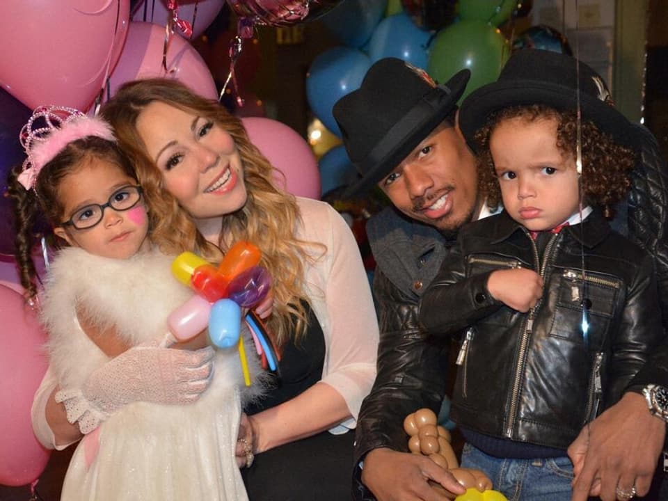 Moroccan und Monroe posieren mit Mariah Carey und Nick Cannon. Im Hintergrund sind Luftballone zu sehen.