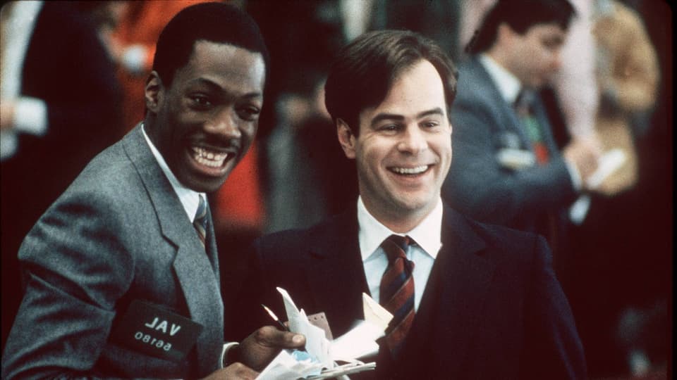 Film-Still aus «Trading Places»: Murphy und Dan Aykroyd stehen lachend nebeneinader. 