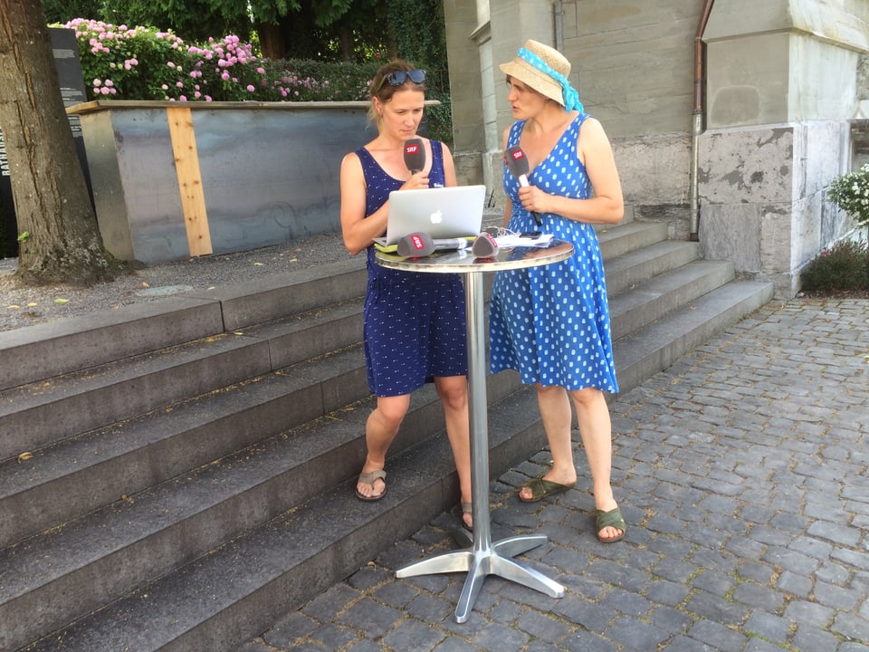 Autorin Martina Clavadetscher (links) und Redaktorin Mirjam Breu besprechen die Livesendung vor dem Denkmal in Stans.