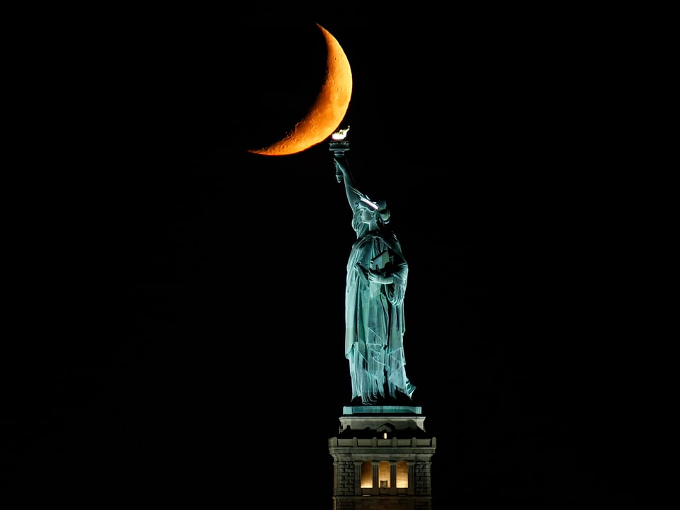 Der Mond hinter der Freiheitsstatue.