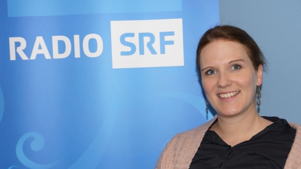 Lea Pfister-Scherer sitzt vor dem SRF Musikwelle Logo.