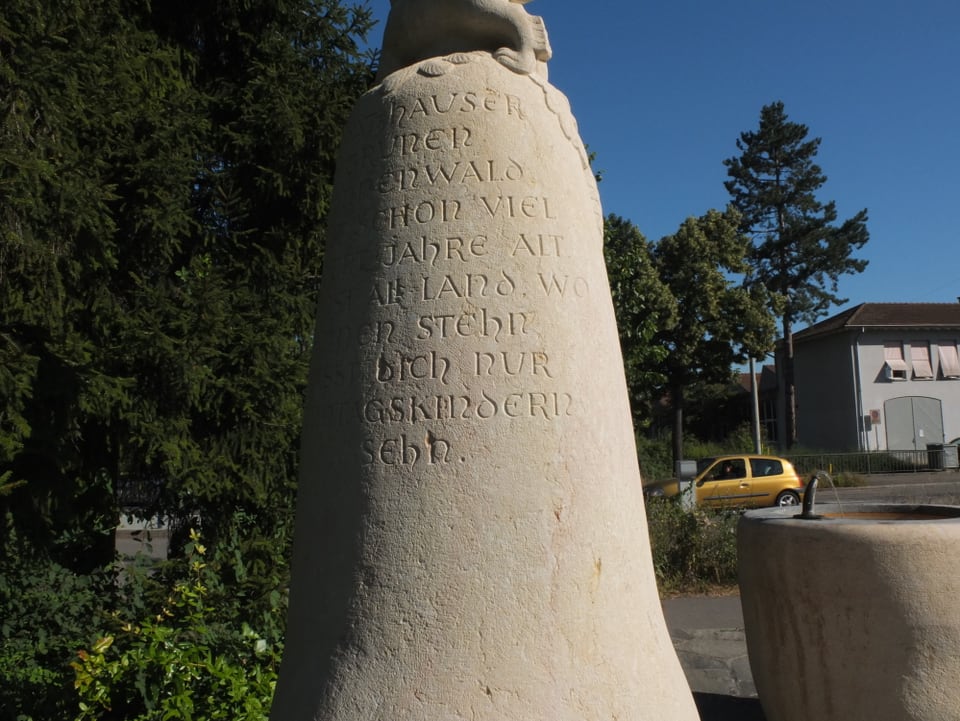 Weisser Obelisk mit eingemeisselten Buchstaben. 