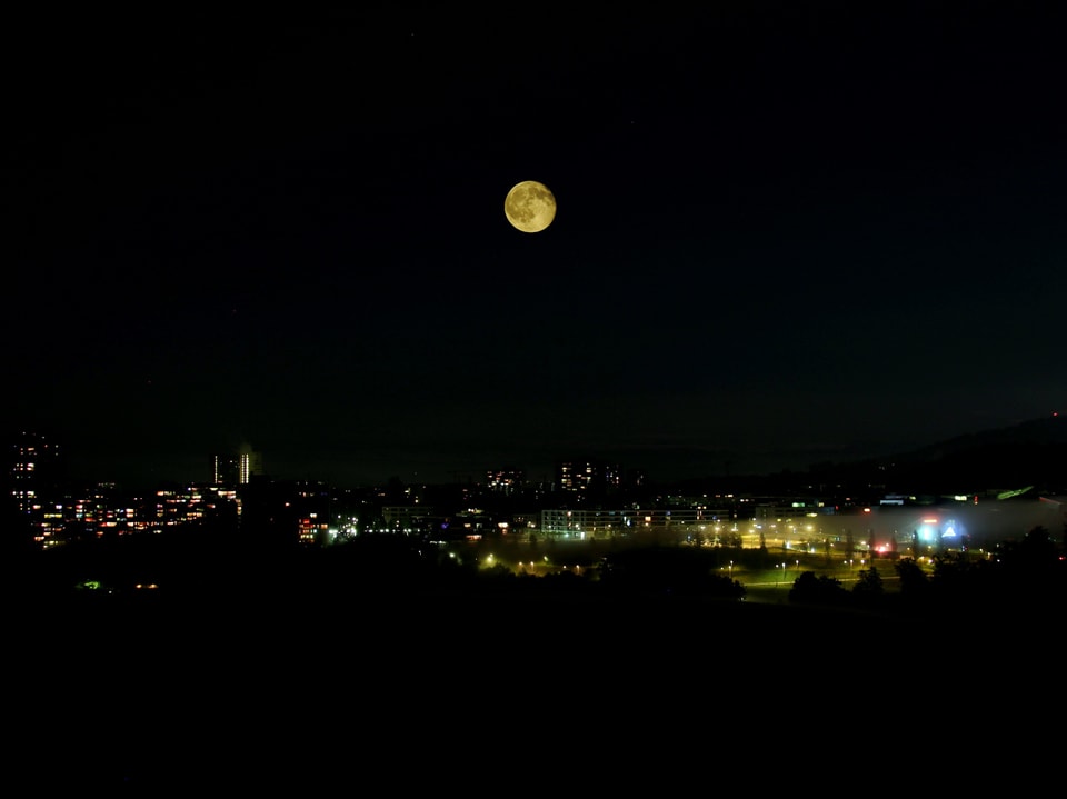 Unten am Bild die Lichter der Stadt Bern, darüber der Vollmond.