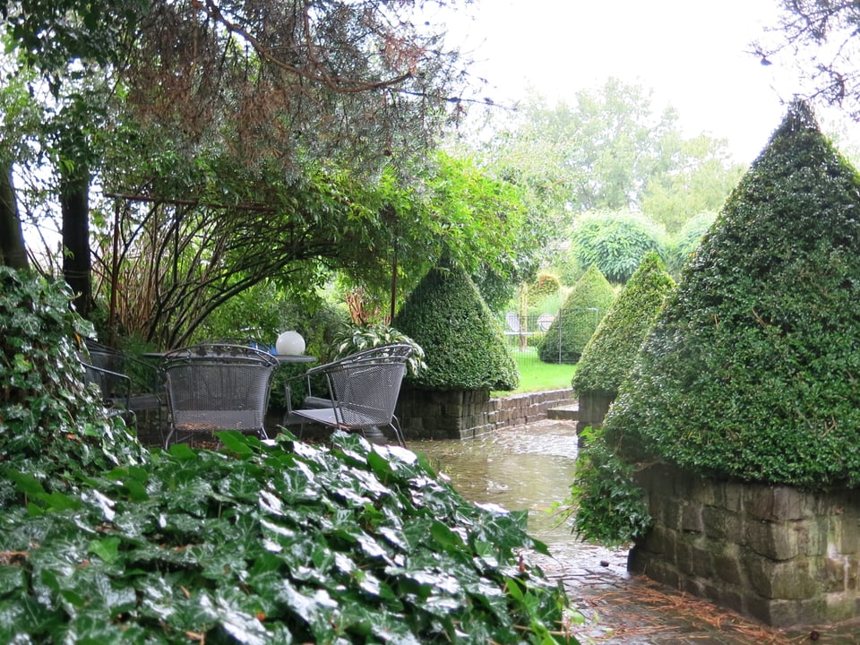 Einer der Gartensitzplätze mit zylinderförmigen Eiben.
