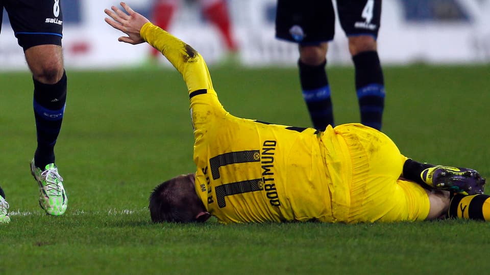 Marco Reus wälzt sich nach dem rüden Foul von Paderborns Marvin Bakalorz verletzt am Boden.