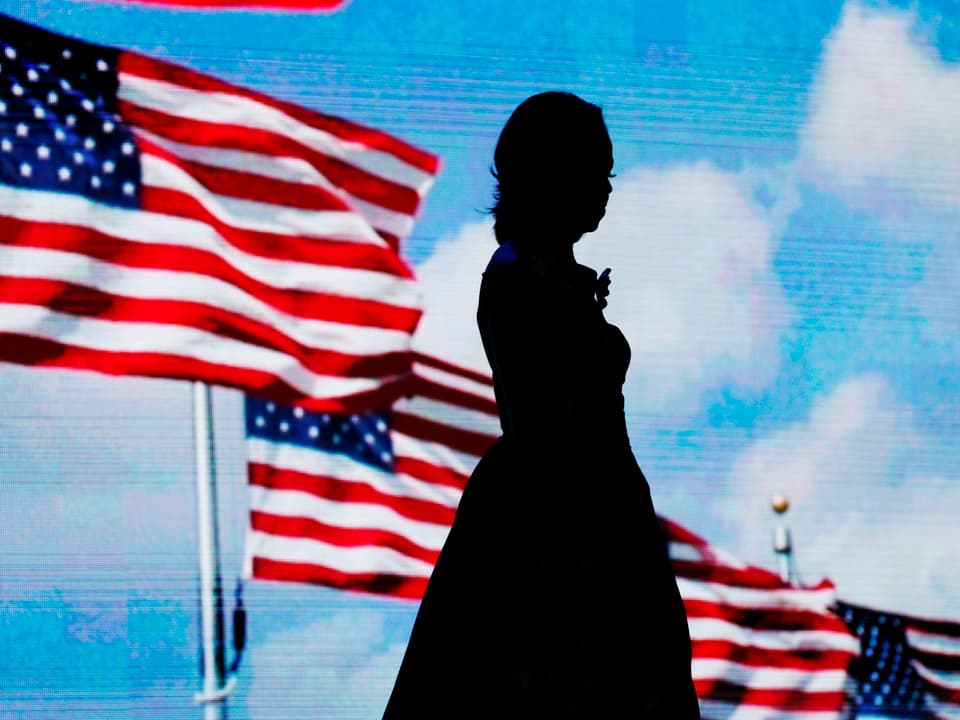 Die Silhouette von Michelle Obama vor US-Flaggen