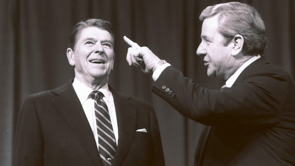 Links ein Mann, der nach oben schaut (Reagan), rechts ein Mann, der mit dem Finger nach  oben zeigt (Falwell).
