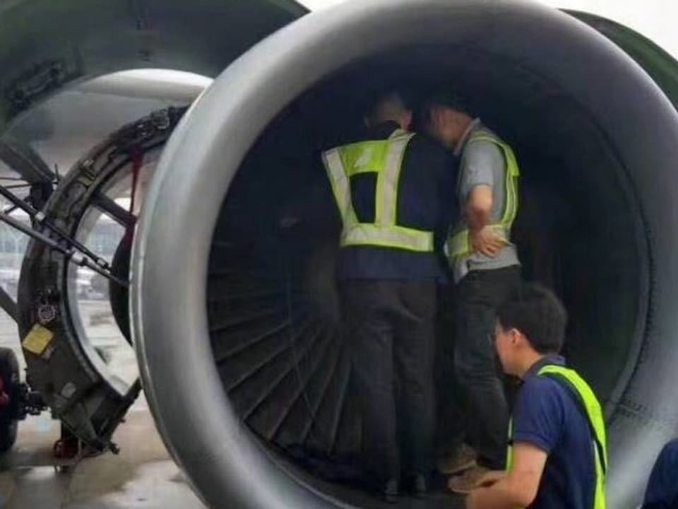 Zwei Männer stehen in einer Flugzeug-Turbine.