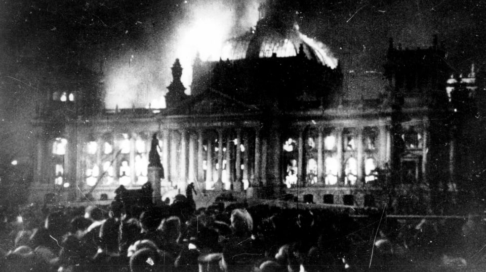 Schwarzweissfoto, Film-Standbild: Menge vor brennendem Reichstagsgebäude