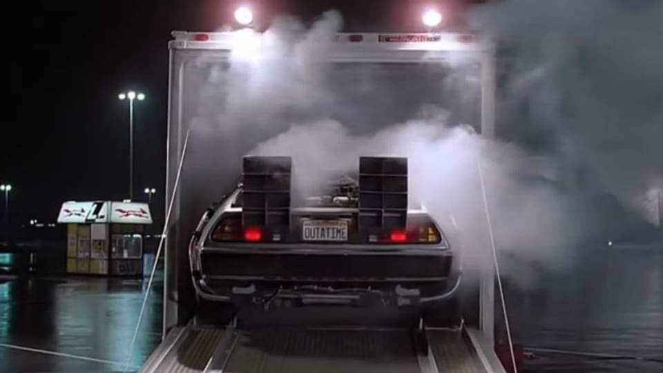 Ein futuristisches Auto fährt rückwärts aus einem verrauchten Lieferwagen.