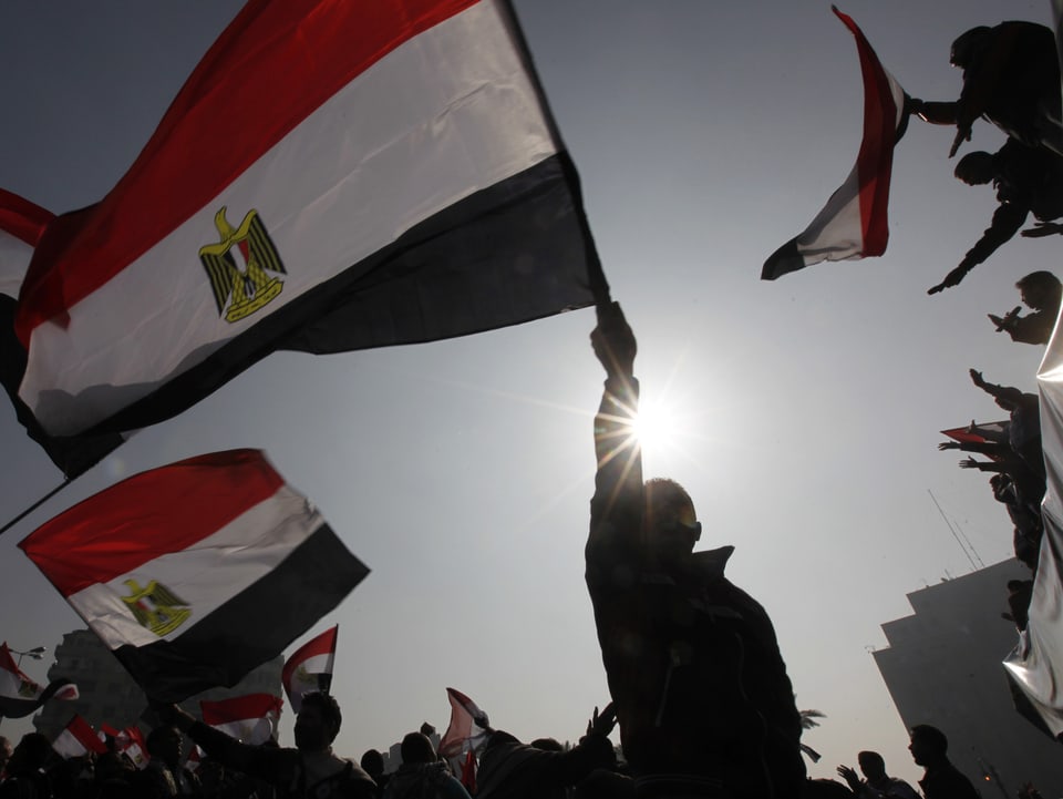 Demonstranten schwenken ägyptische Flaggen.