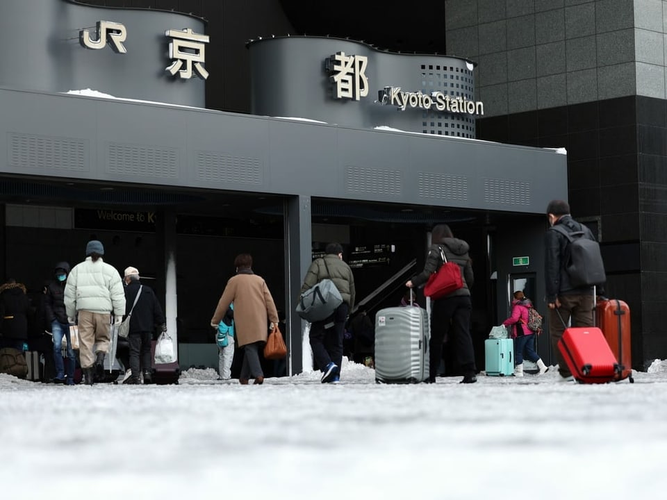 Menschen mit Koffern in Bahnhof in Kyoto