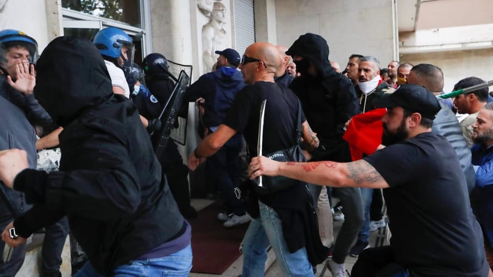 Demonstranten in Rom bedrängen die Sicherheitsdienste mit Stöcken (9. Oktober 2021).
