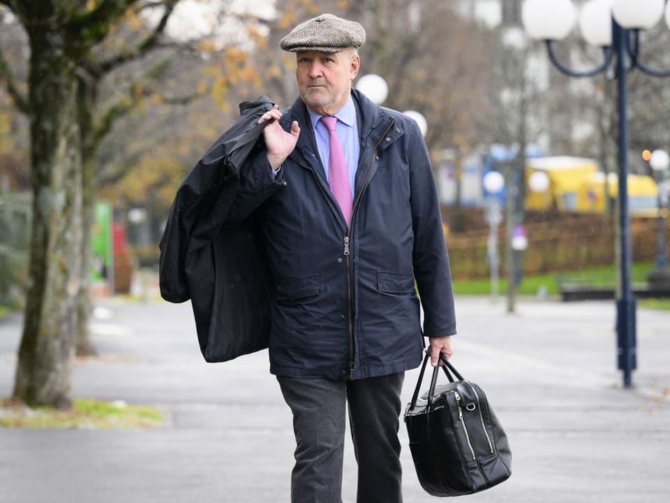 Älterer Mann in Mantel und Mütze trägt Taschen auf Strasse
