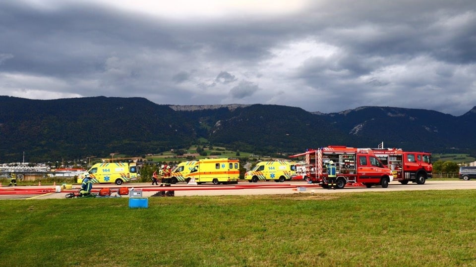 Ambulanzen und Feuerwehrfahrzeuge auf dem Rollfeld, im Hintergrund Jura-Kette