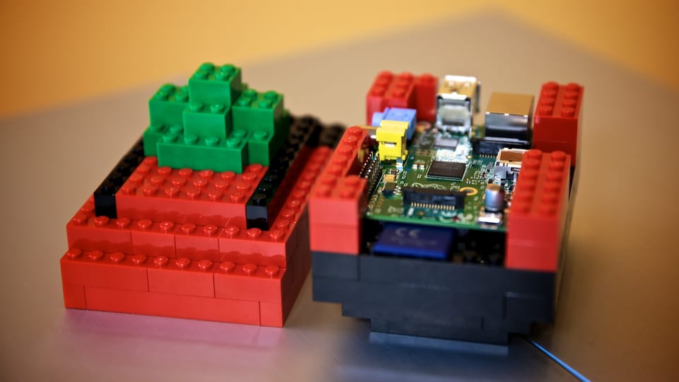 Die Platine des Raspberry Pi sitzt in einem Gehäuse aus roten und schwarzen Legosteinen.