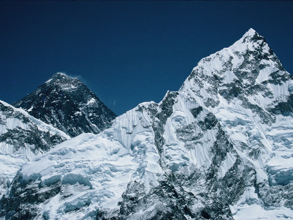 Die Spitze des Mount Everest, die hinter dem Nuptse hervorlugt.