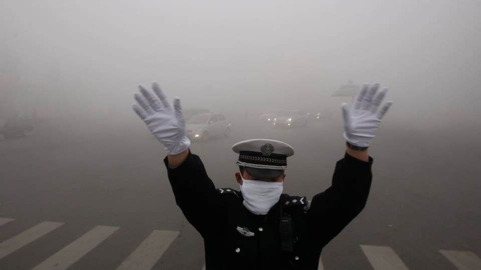 Ein Polizist mit Atemschutzmaske regelt den Verkehr