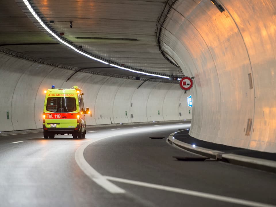 Ein Signalgelber Lieferwagen der Feuerwehr, angeschrieben mit ABC-Messwagen, fährt durch den leeren Uetlibergtunnel