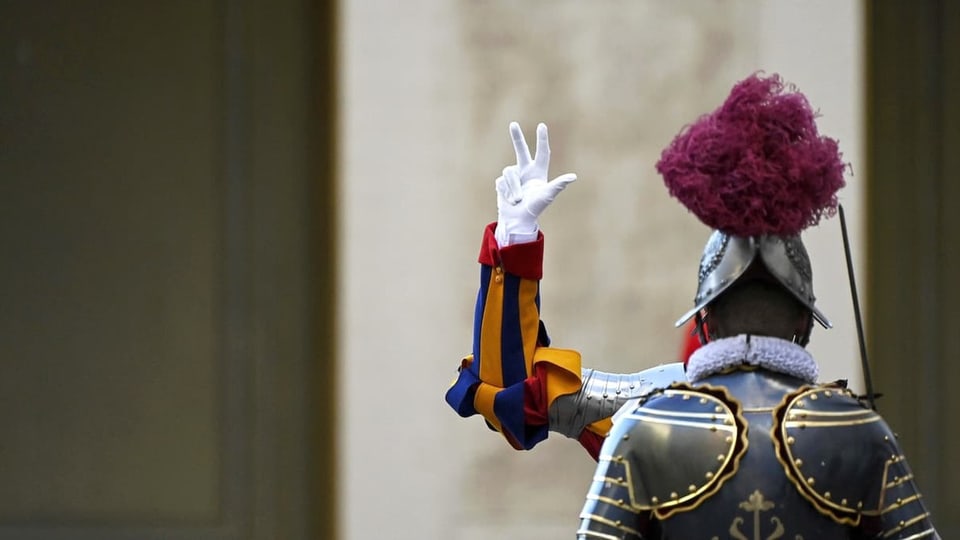 Ein Soldat der Schweizergarde erhebt drei Finger zum Schwur, vor ihm steht ein anderer Gardist.