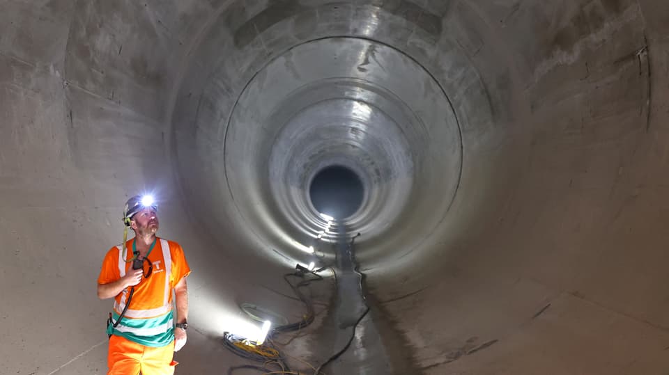 Ein Ingenieur in einem riesigen Abwasserrohr.