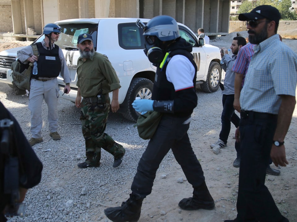 UNO-Inspektoren mit Gasmasken bereiten sich auf Probenentnahmen in zerbombten Häusern vor. (reuters)