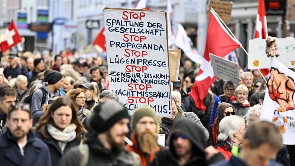 Schild bei Demonstration mit STOP