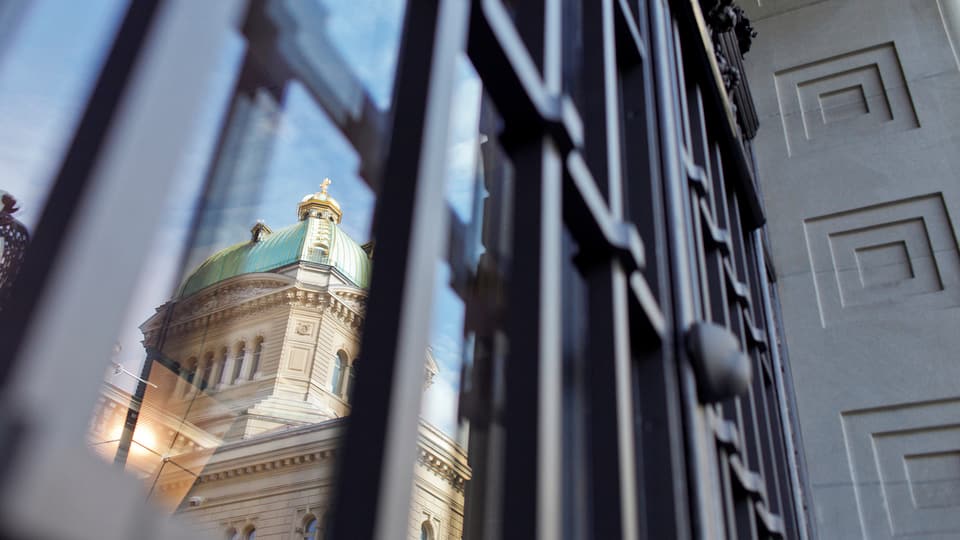 Bundeshaus spiegelt sich in Fenster von Nationalbank.