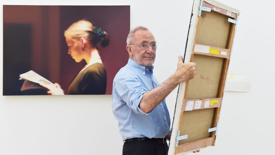 Der Maler Gerhard Richter mit einem Bild in der Hand vor einem seiner Bilder,