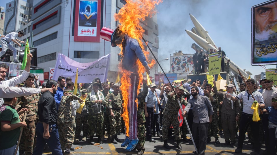 Demonstranten verbrennen eine Puppe mit USA-Hut