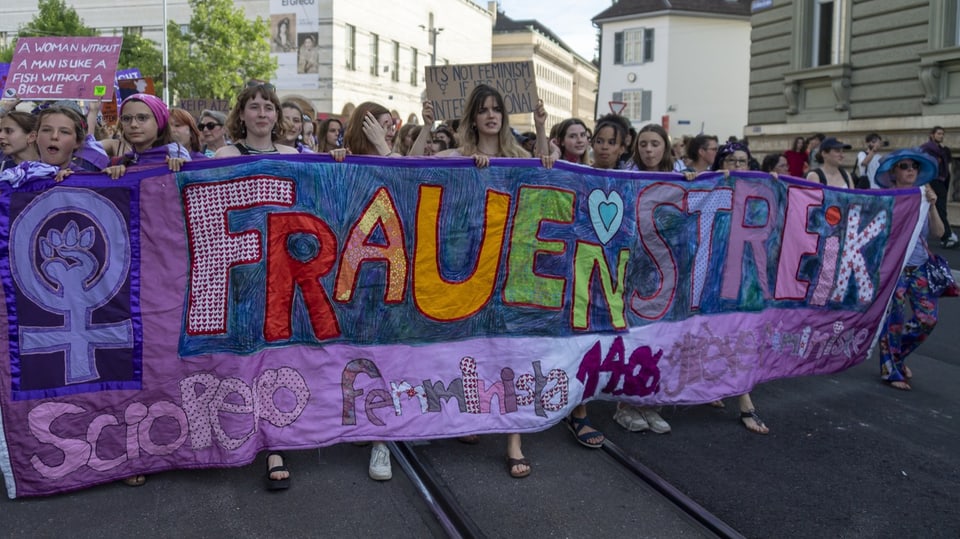 Buntes Plakat mit der Aufschrift «Frauenstreik», getragen von vielen Frauen