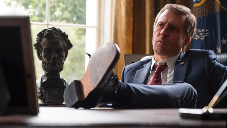 Sam Rockwell als George W. Bush mit den Füssen auf dem Pult des Oval Office.