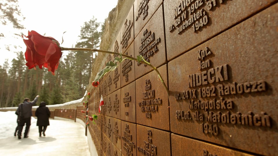 Eine Rose steckt zwischen zwei Erinnerungstafeln der Gedenkstätte zum Massaker in Katyn.