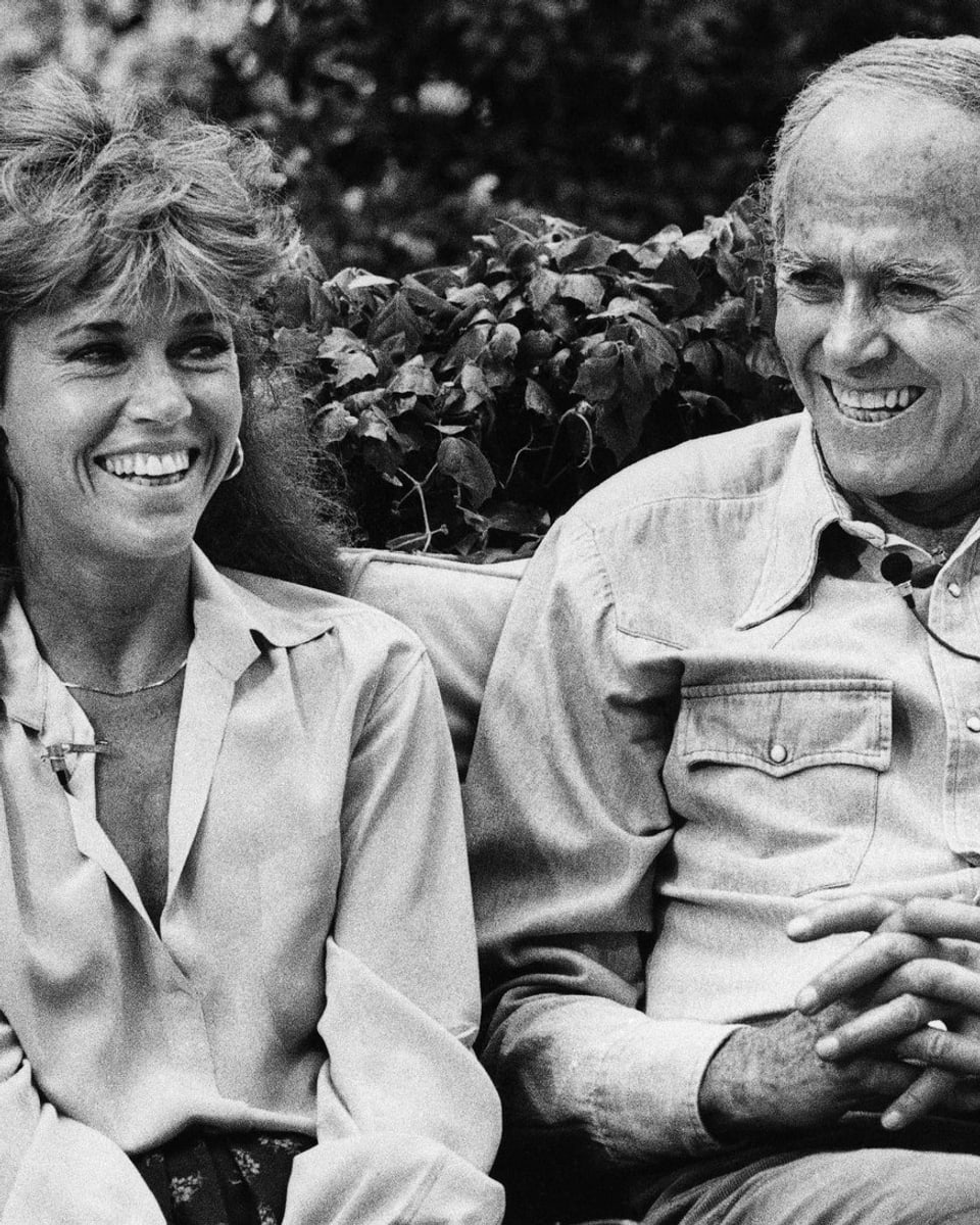 Jane und Henry Fonda sitzen auf Bank und lachen