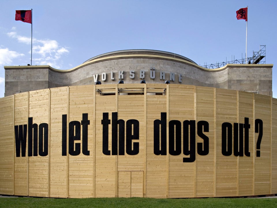 Die Volksbühne in Berlin ist in Bretter eingepackt, darauf steht: Who let the dogs out?