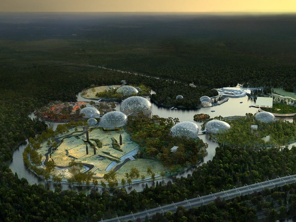 Ein futuristische Anlage mit Wasser und kugelförmig überbauten Inseln in einem Wald.