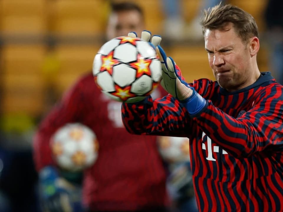 Manuel Neuer hält mit grimmiger Miene den Ball fest.