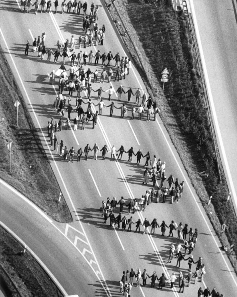 Menschenkette auf einer Autobahn auf einer Schwarz-weiss-Aufnahme.