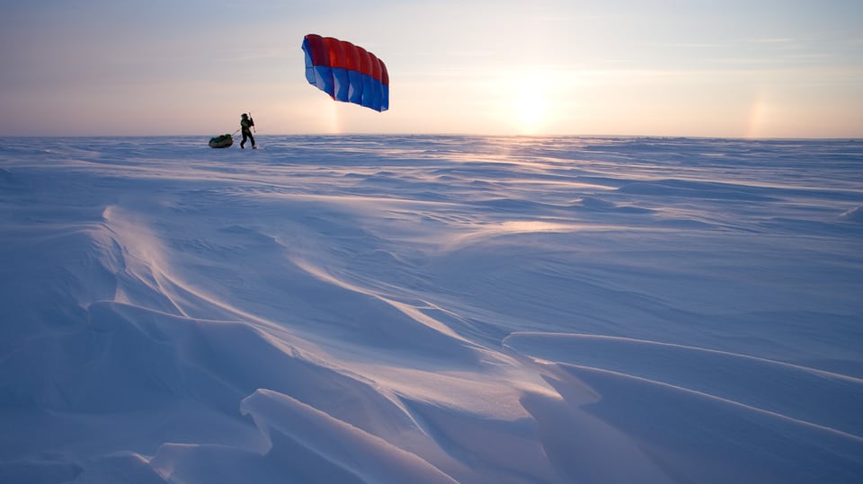 Mann in der Arktis mit Windsegel