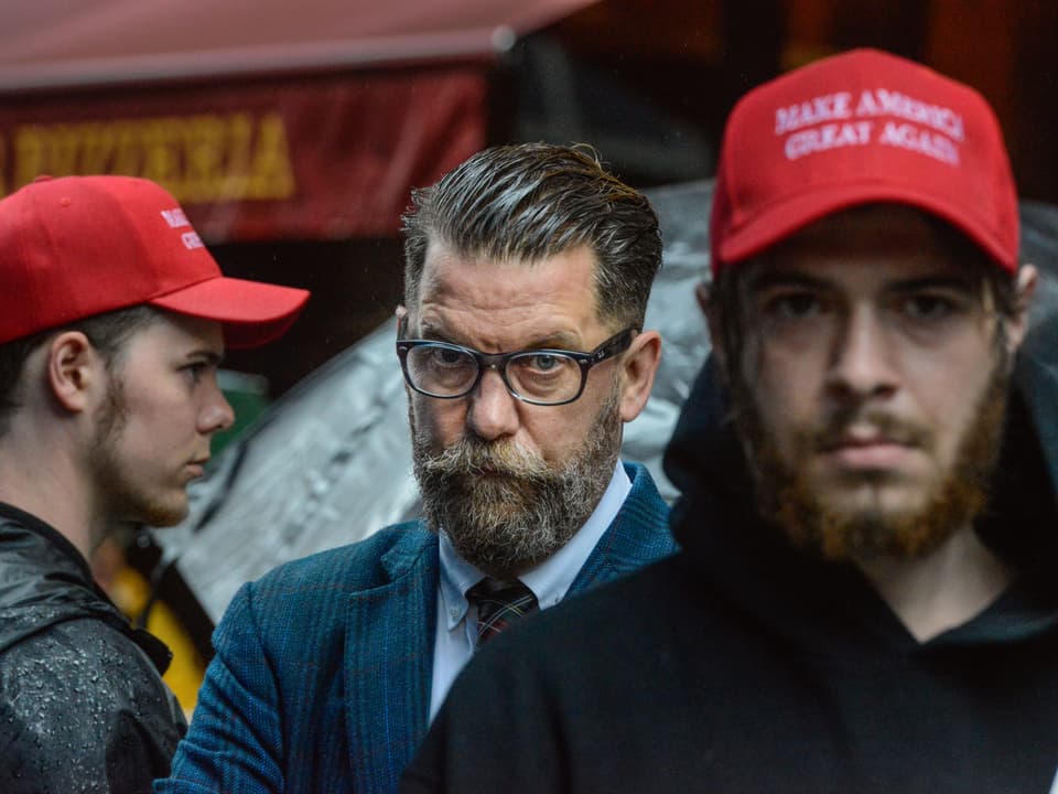 Zwei junge Männer mit einer roten Trump-Kappe, dazwischen Gavin McInnes.