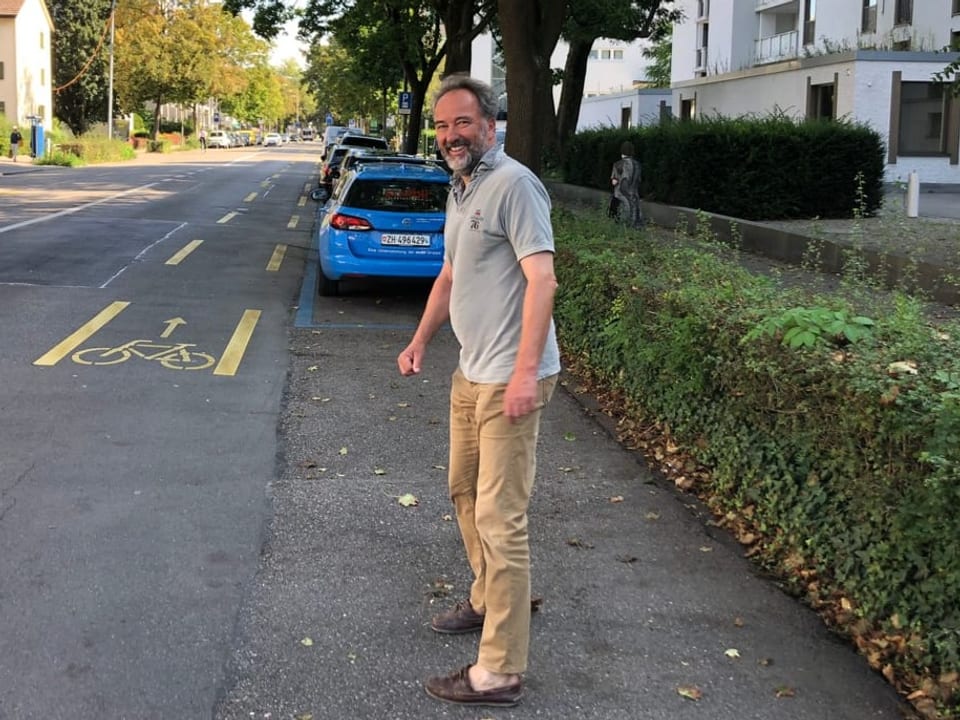 Der Präsident des VCS Zürich steht auf der Strasse und lacht herzlich in die Kamera