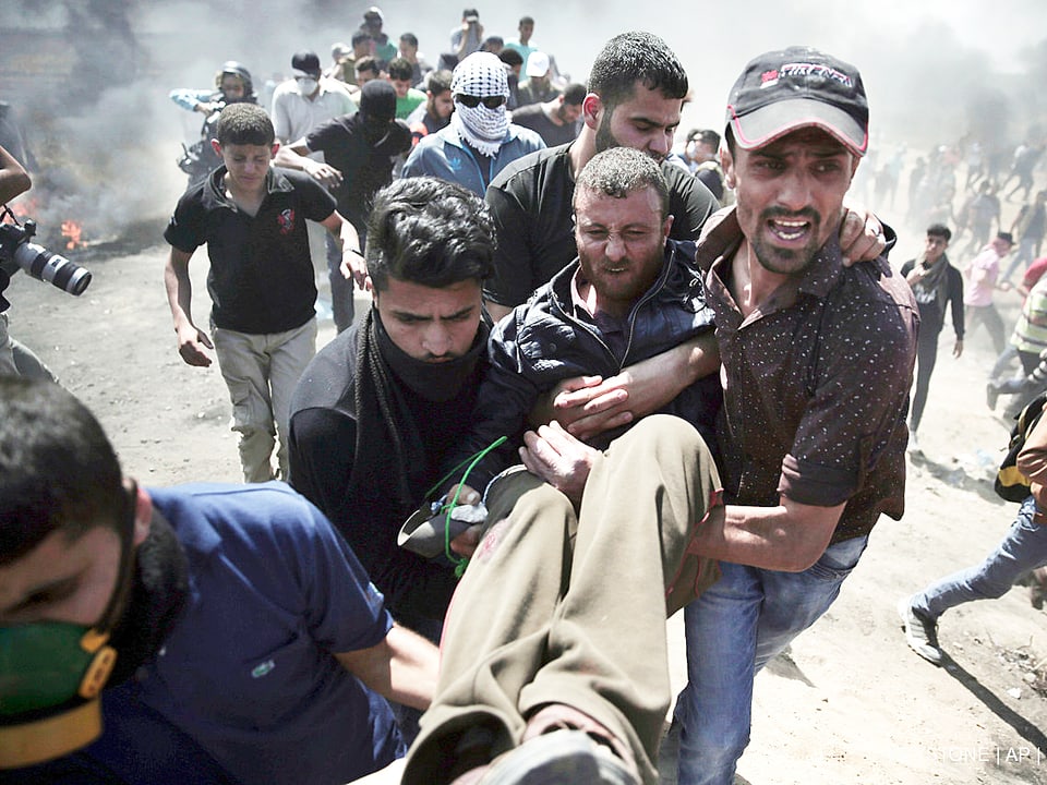 Männer tragen einen verletzten Palästinenser in Gaza weg.
