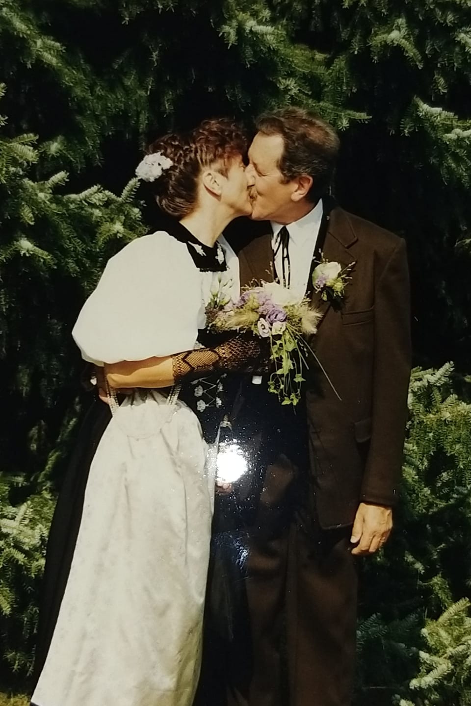 Das Brautpaar, sie in Berner Tracht, er in braunem Anzug, steht küssend da.
