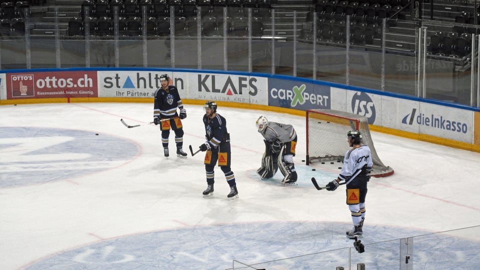 Eishockeyfeld mit vier Spielern beim Training. 