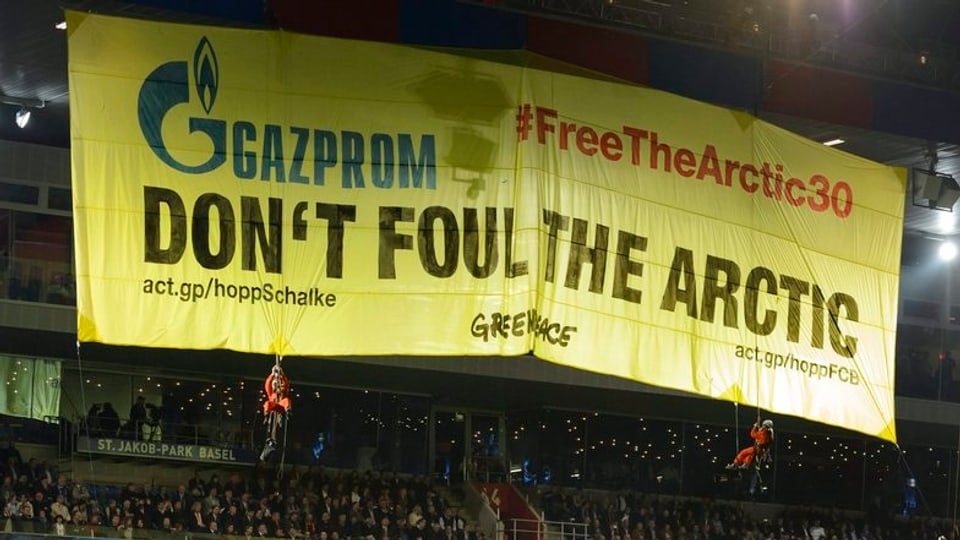 Gelbes Banner von Greenpeace hängt im St. Jakob-Park Fussballstadion.