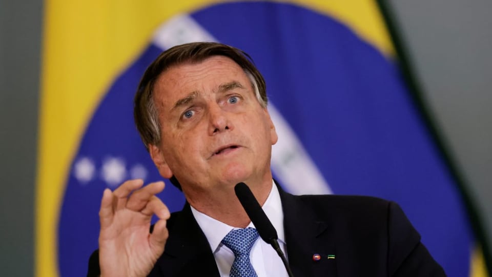 Jair Bolsonaro spricht vor einer brasilianischen Flagge